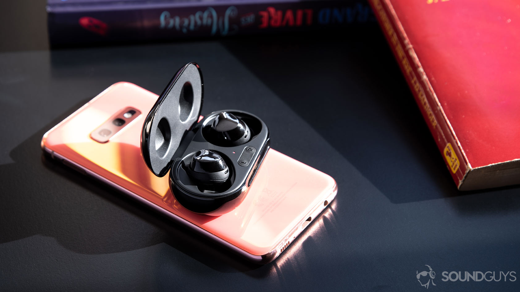 A picture of the Samsung Galaxy Buds Plus open atop a Samsung Galaxy S10e with PowerShare charging.