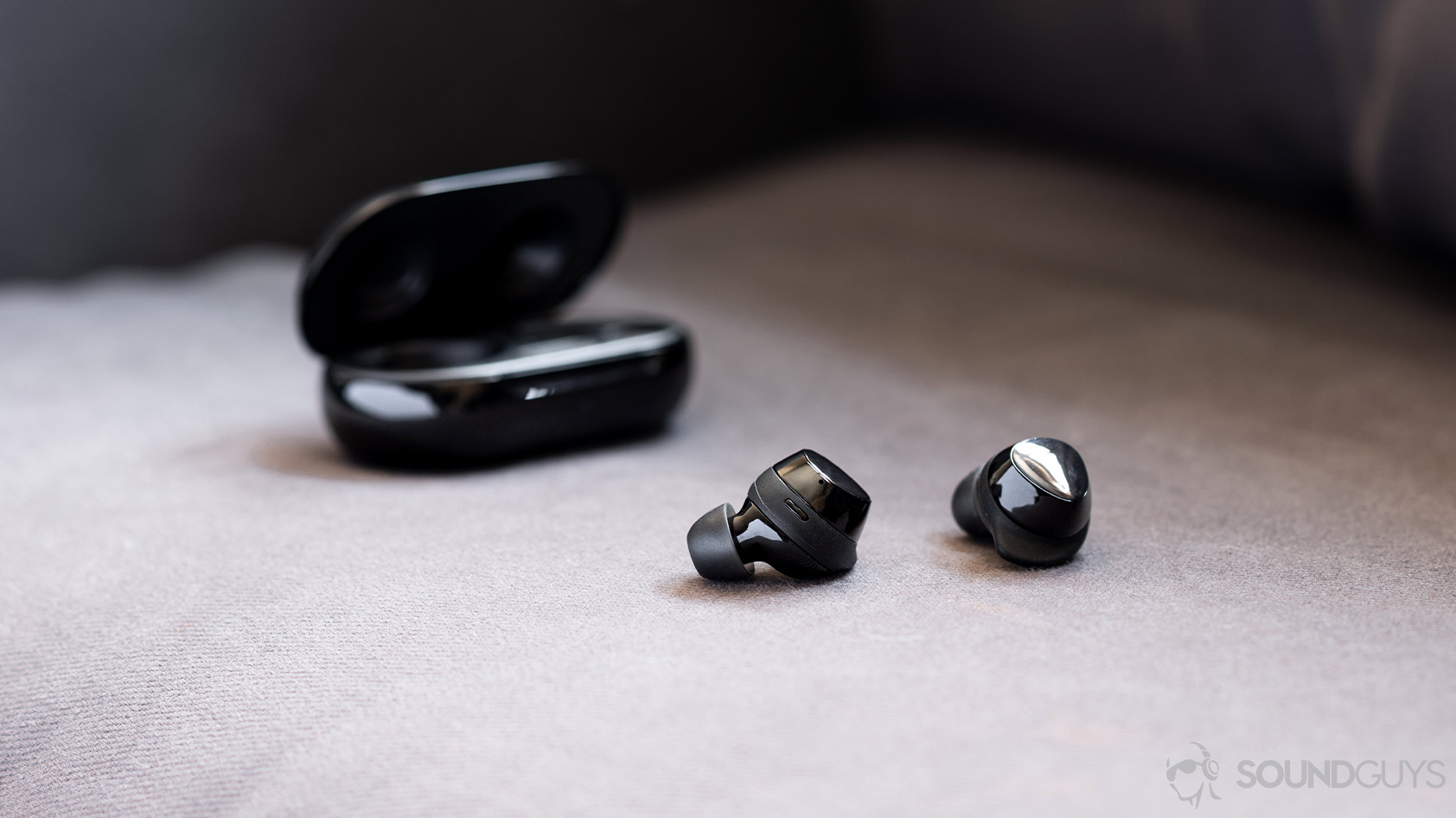 A picture of the Samsung Galaxy Buds Plus earbuds out and in front of the case, which is open in the background.