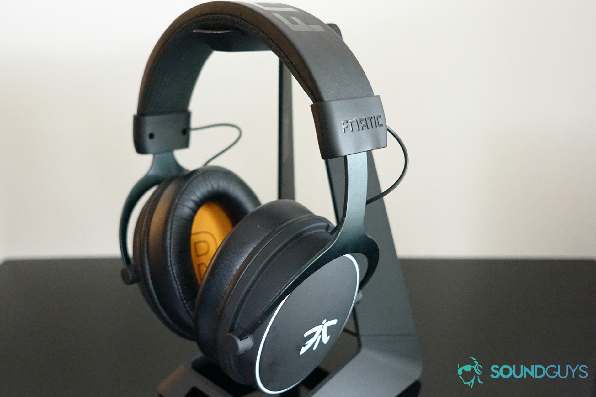 The Fnatic React gaming headset sits on a headphone stand.