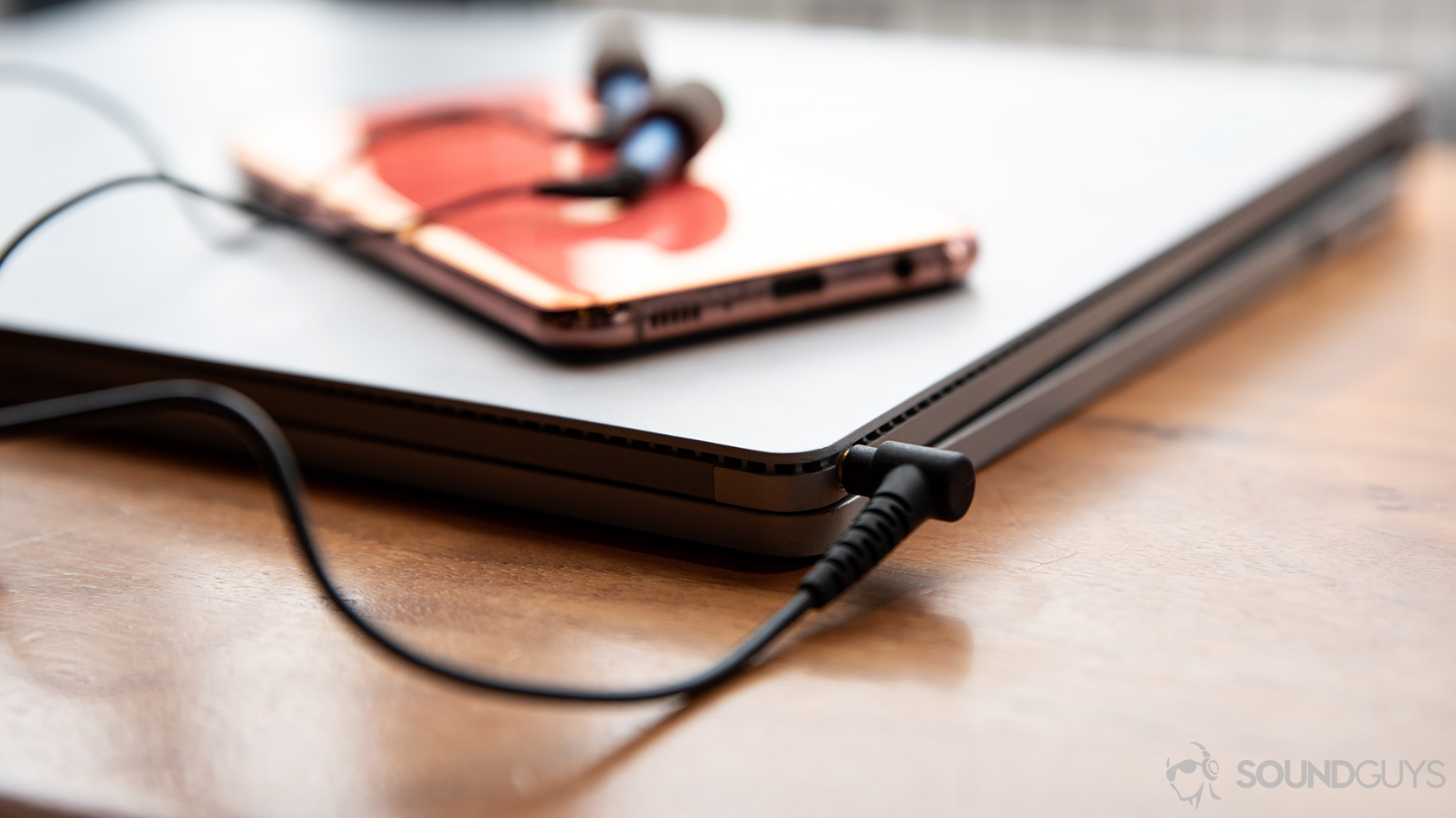 A picture of the Etymotic ER2SE wired earbuds connected to a Microsoft Surface Book laptop with a Samsung Galaxy S10e on top of it.