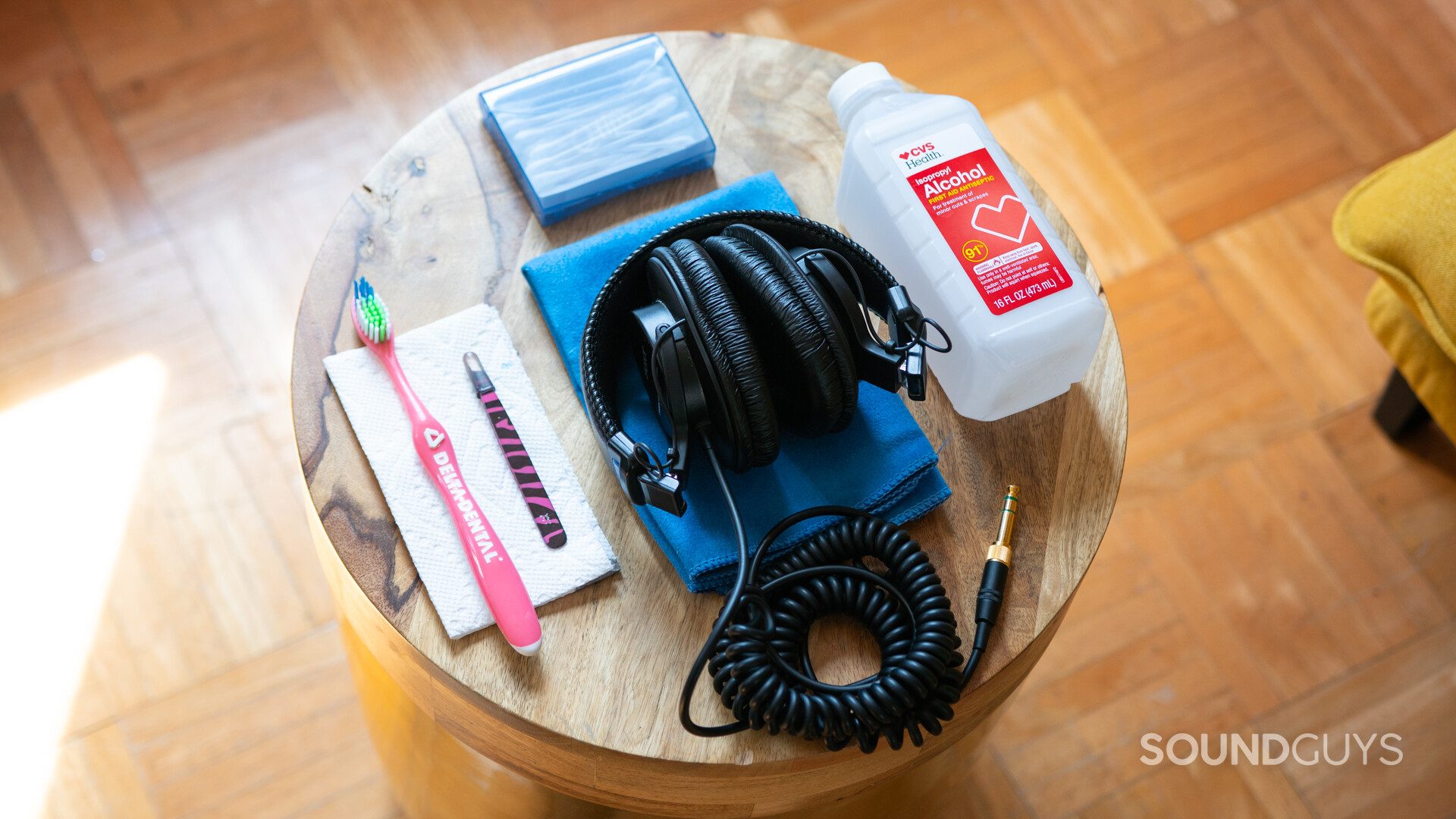 Sony headphones on a wooden stool with cleaning supplies in the sun