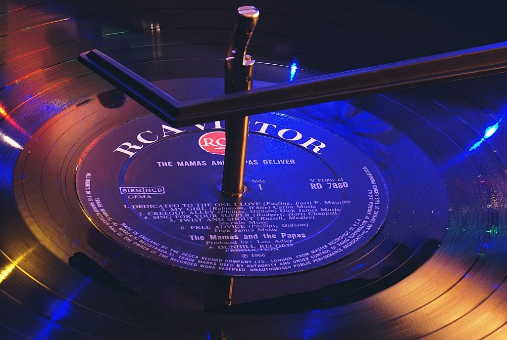 A photo of a vinyl record with a label and producer listed on the front; essential information for those looking how to find new music.