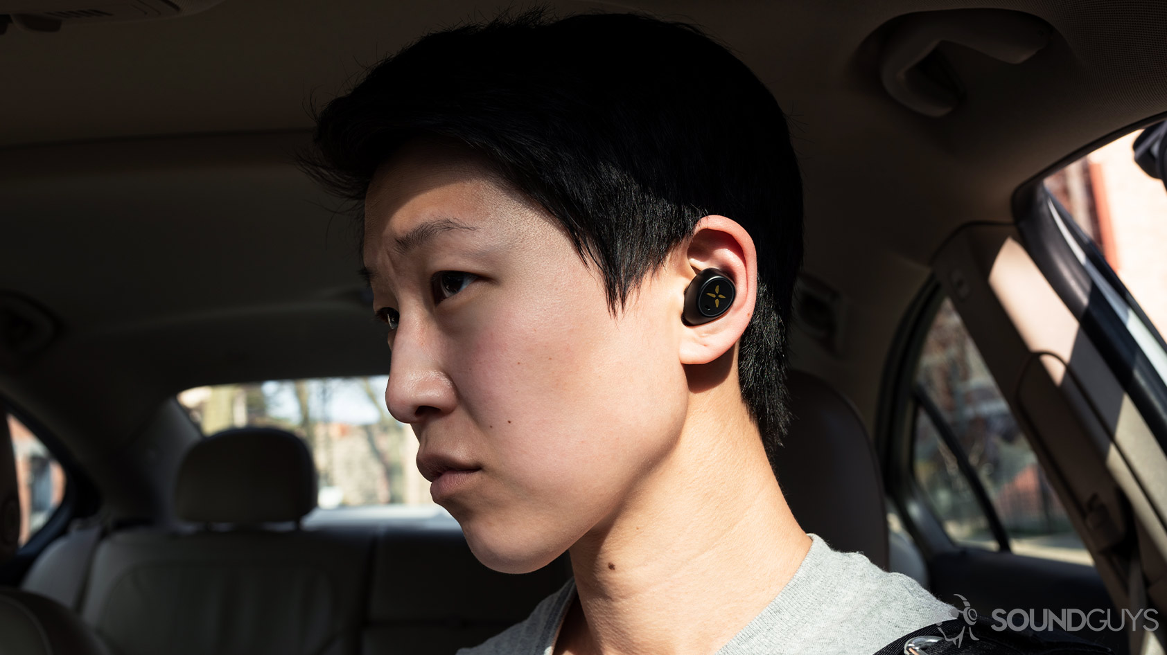 A picture of the Klipsch S1 True Wireless earbuds being worn by a woman in a parked car.
