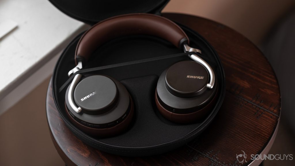 An aerial photo of the Shure Aonic 50-noise cancelling headphones open carrying case revealing the headphones in brown.