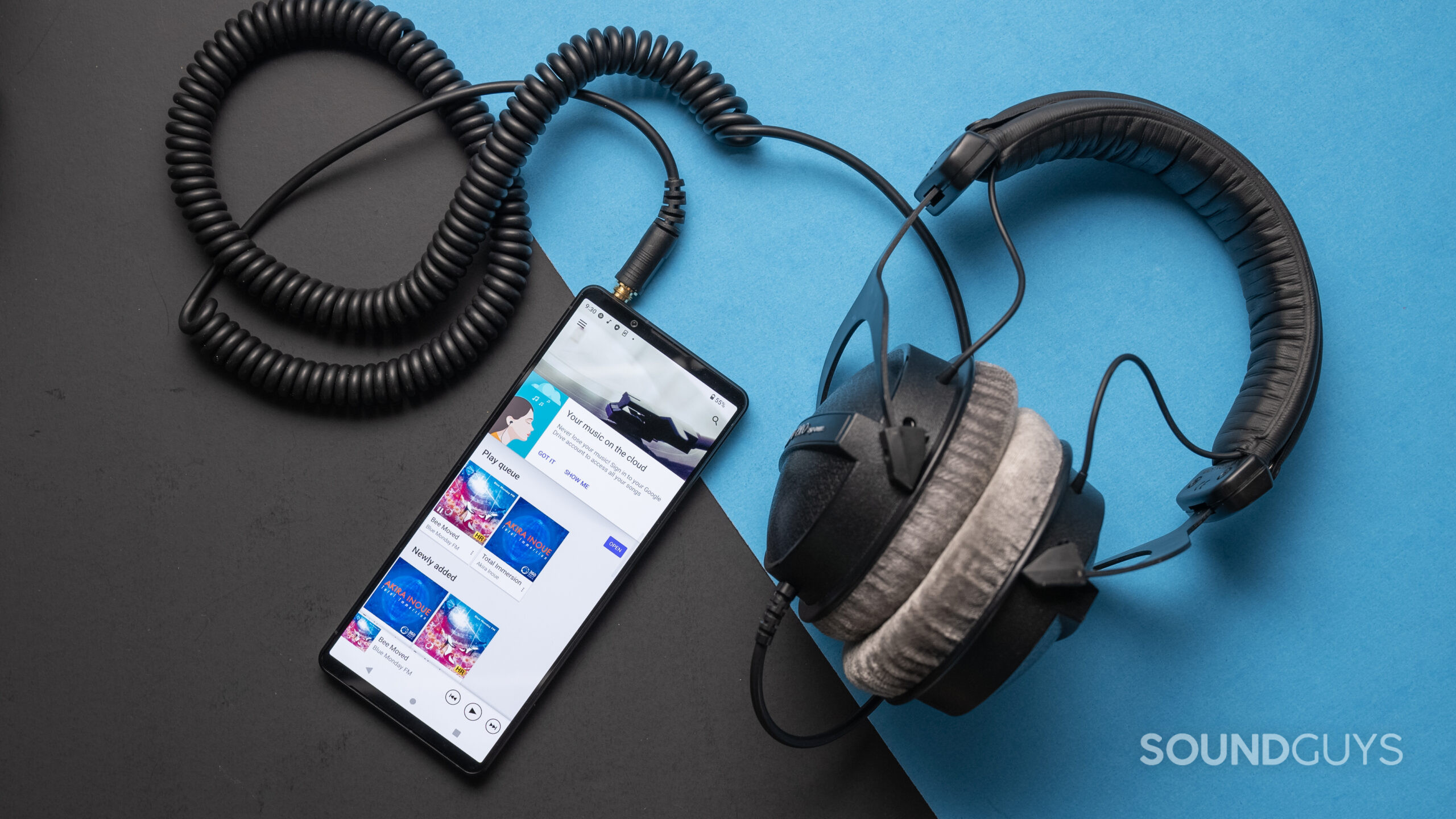 A pair of corded headphones plugged into a Sony Xperia 1 V phone