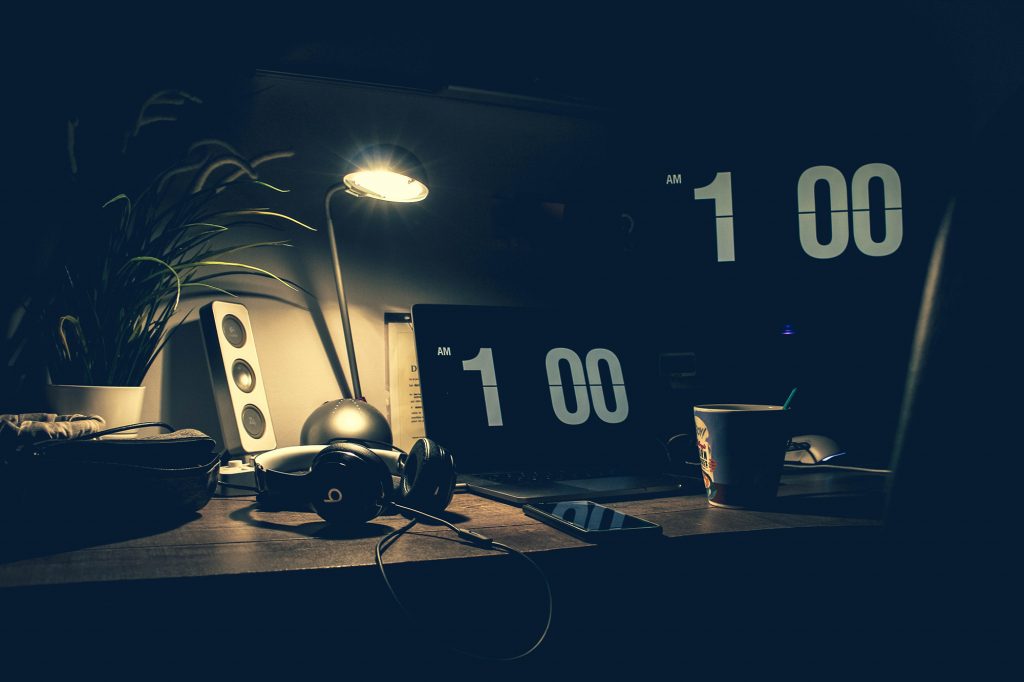 A photo of a desk with laptop, headphones, and monitor at 1:00 am, 