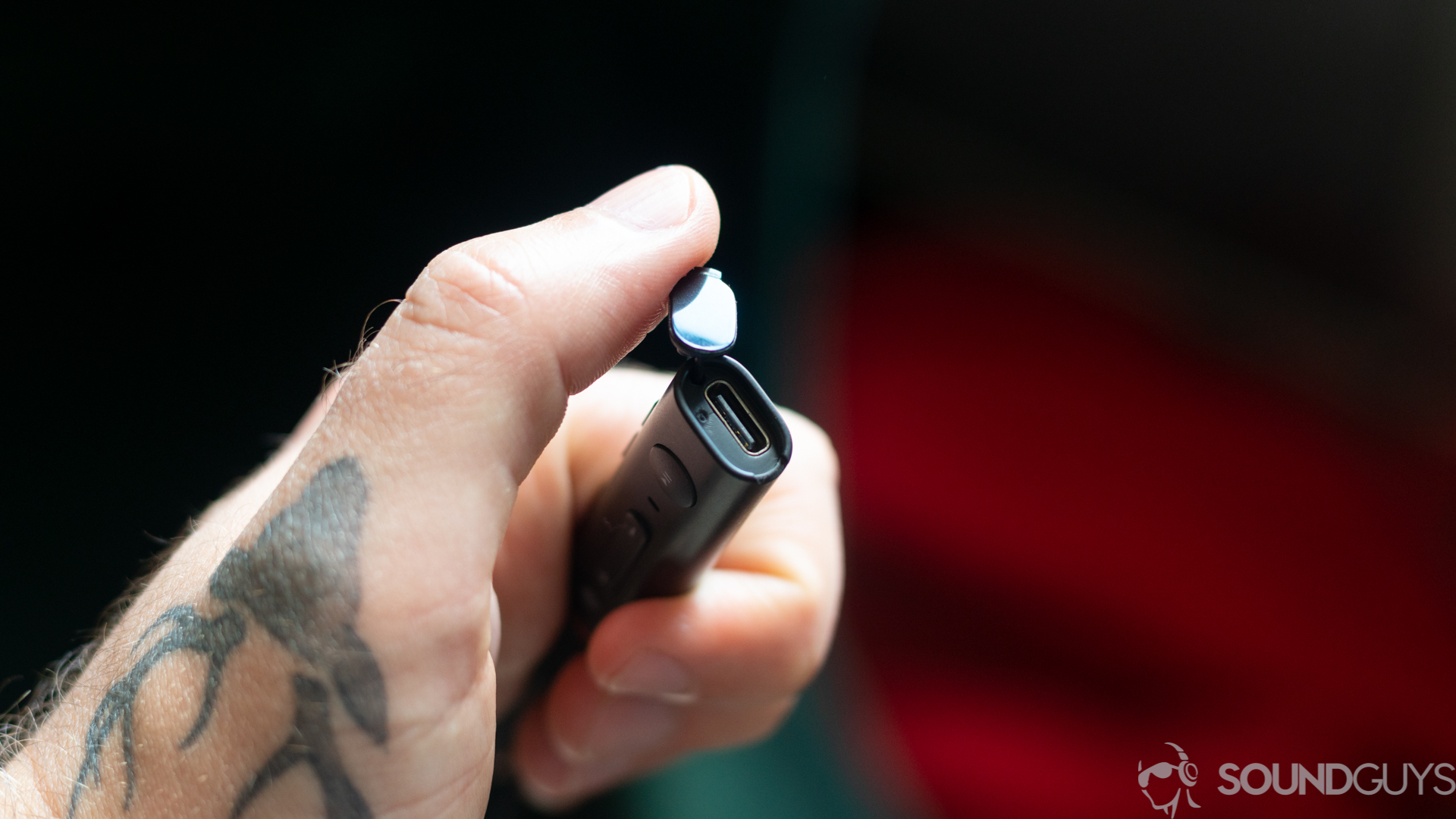 Man holding the lid open of the USB-C input for the 1More Dual Driver ANC Pro earbuds