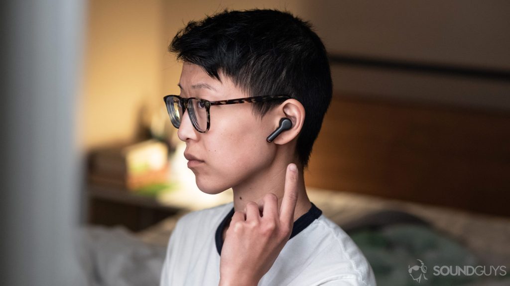 A photo of the Anker SoundCore Liberty Air 2 true wireless earbuds being worn and used by a woman in profile view.