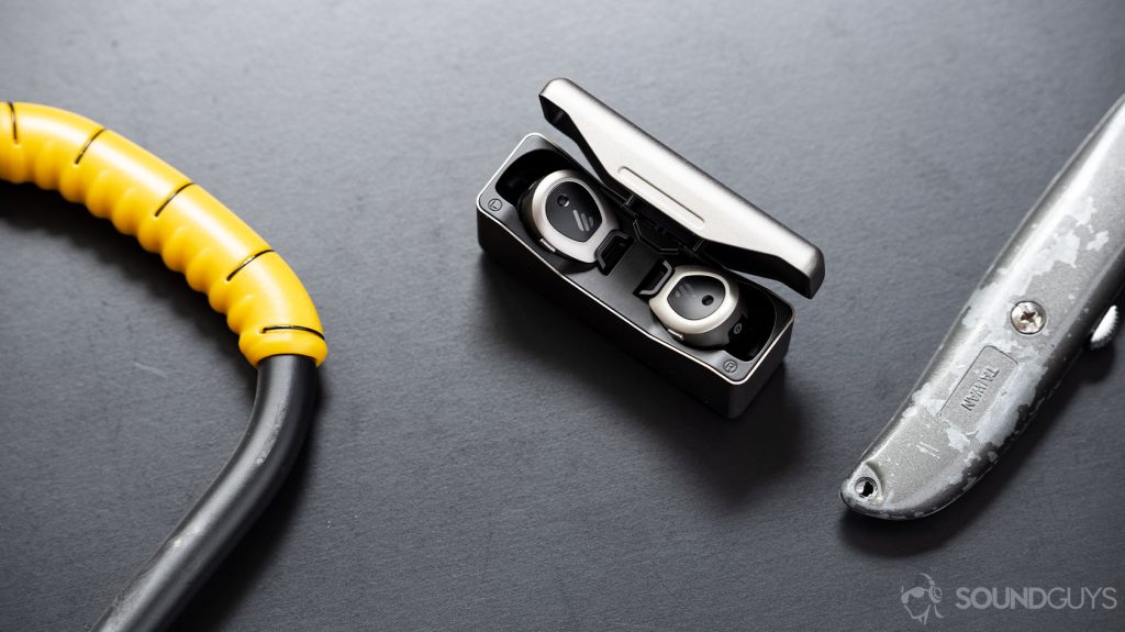 A picture of the Edifier TWS NB true wireless noise cancelling earbuds in the charging case next to a bike lock and box opener.