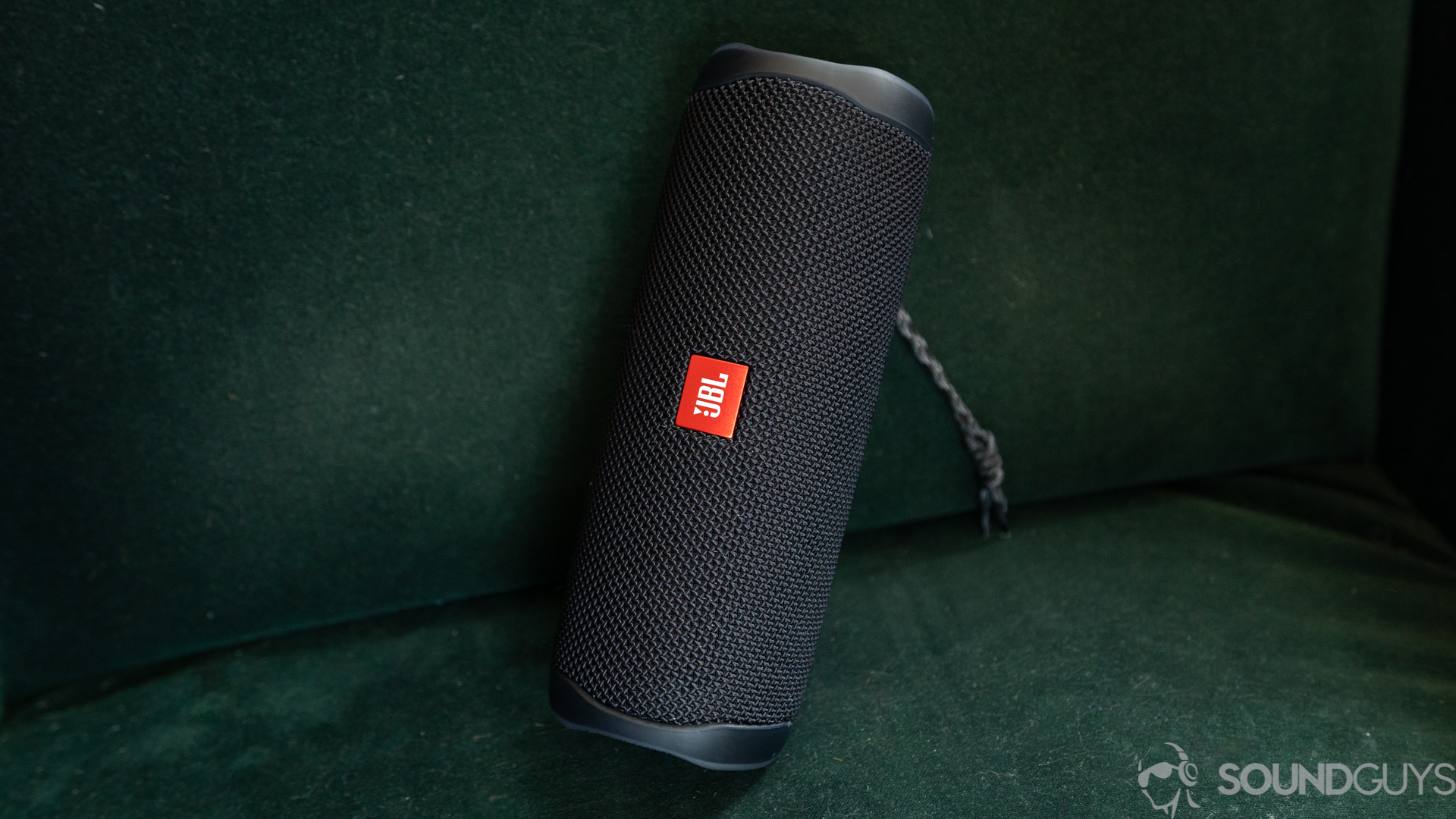 JBL FLip 5 on a green couch with logo visible