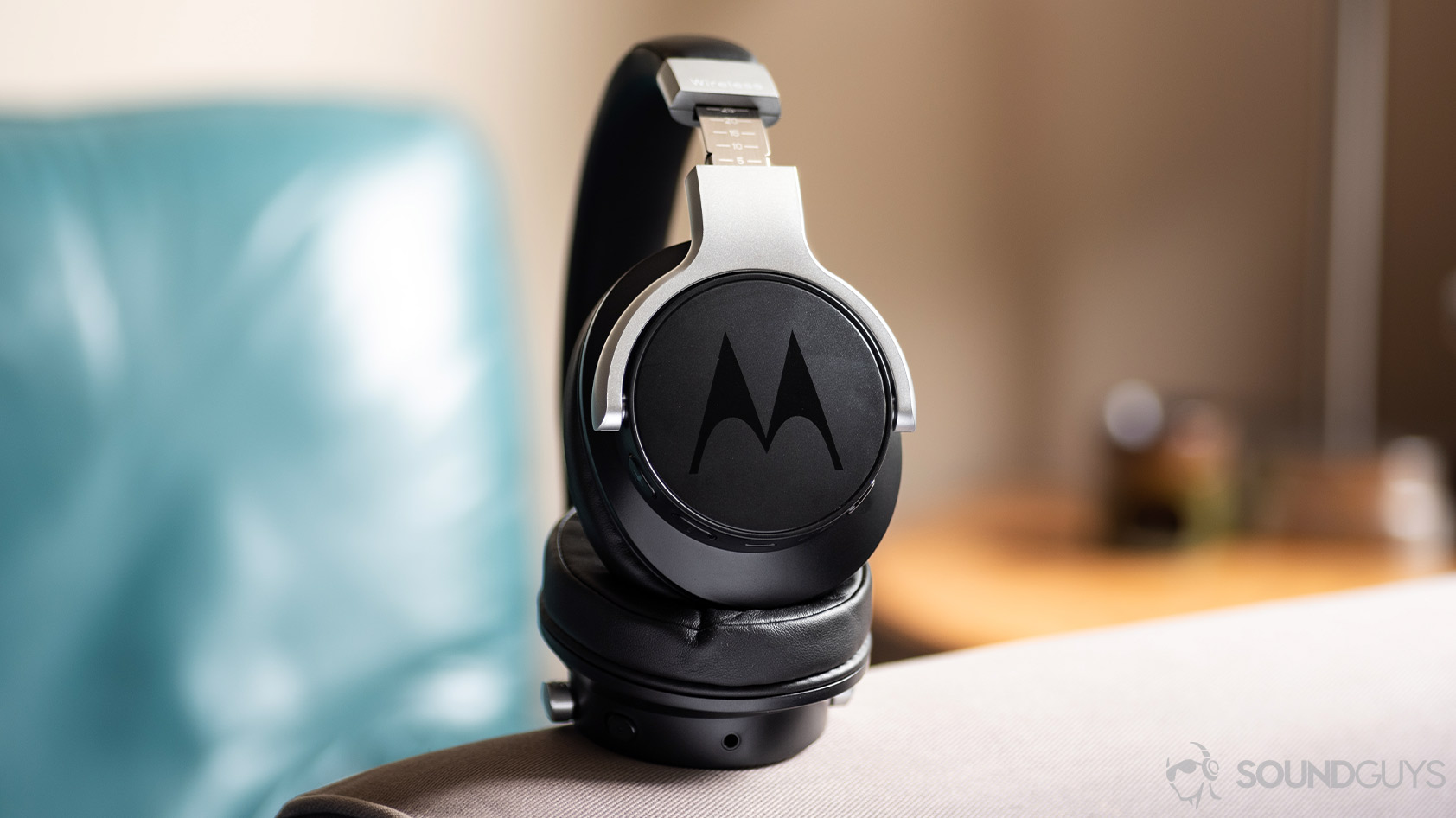 A photo of the Motorola Escape 500 ANC noise canceling headphones propped up on a grey cloth surface.