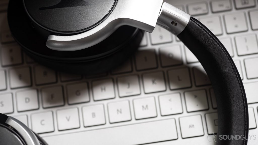 A photo of the Motorola Escape 500 ANC noise canceling headphones' headband and rotating ear cups on a laptop keyboard.
