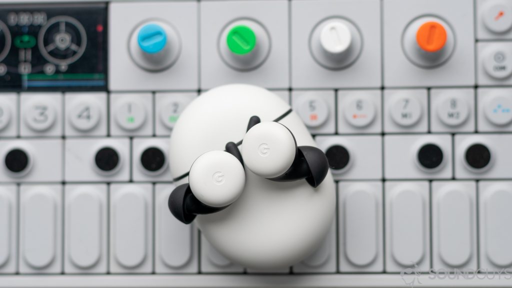 A top-down picture of the new white Google Pixel Buds (2020) on top of a colorful synth from Teenage Engineering.