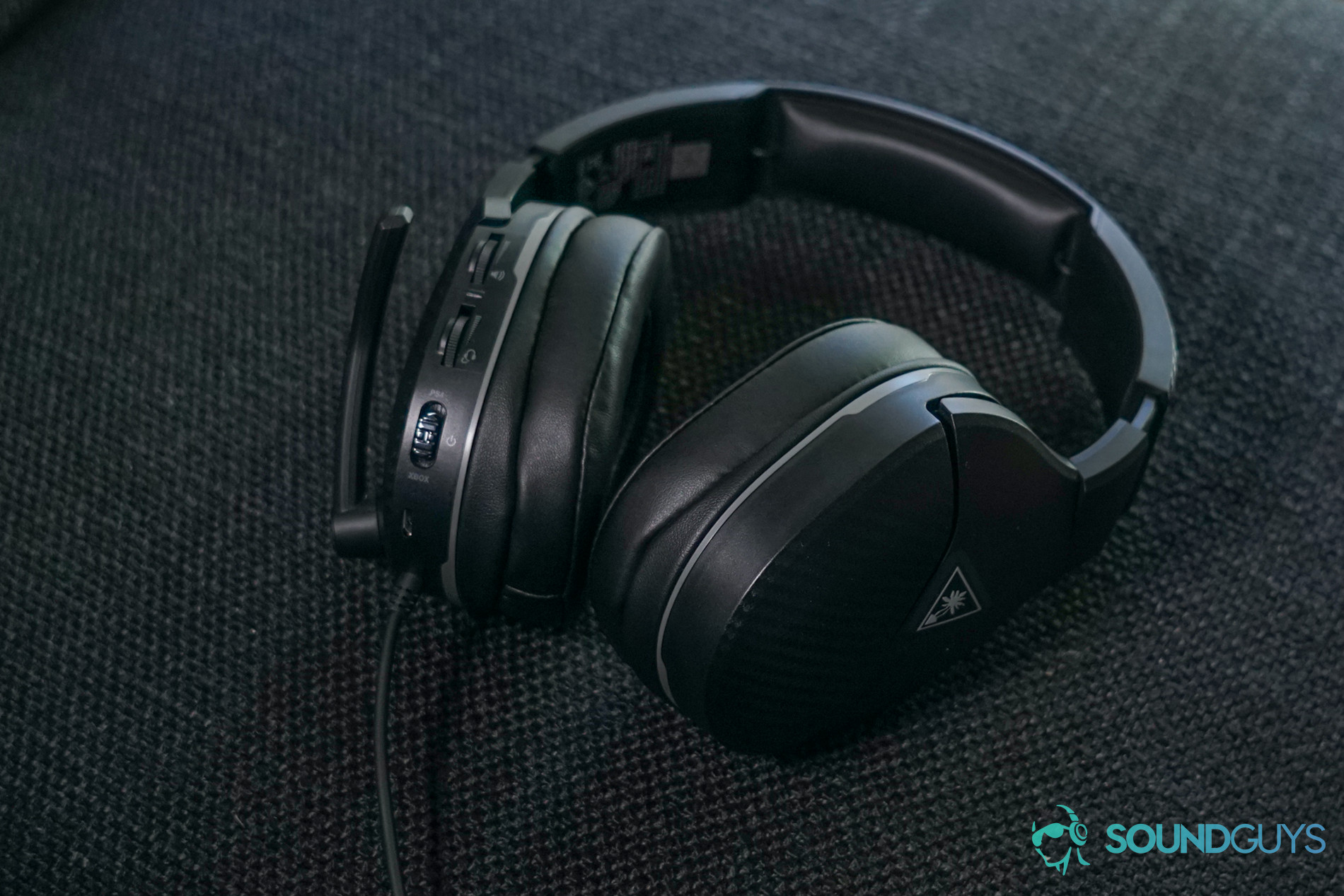 The Turtle Beach Recon 200 sits on a cloth surface with its switches and controls facing up.