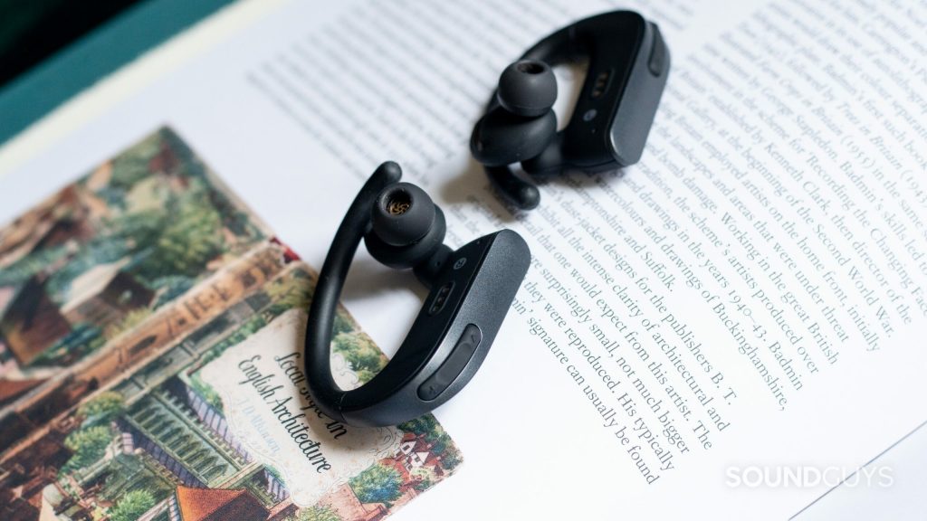 Close-up of the playback controls on the Anker Soundcore Spirit X2 true wireless earbuds on the page of an open book