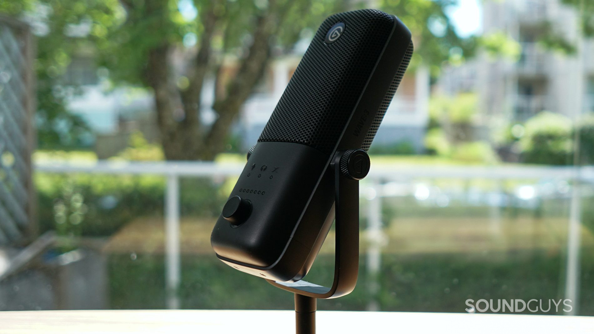 A picture of the Elgato Wave:3 sits near a window on a wooden table.