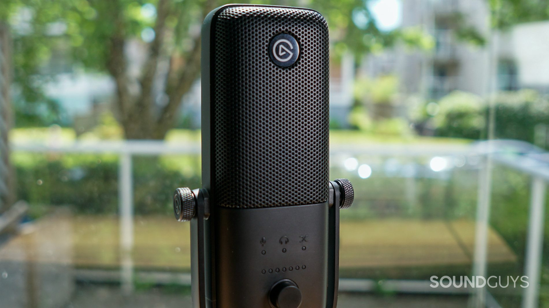 The Elgato Wave:3 microphone in black against an outdoor setting.