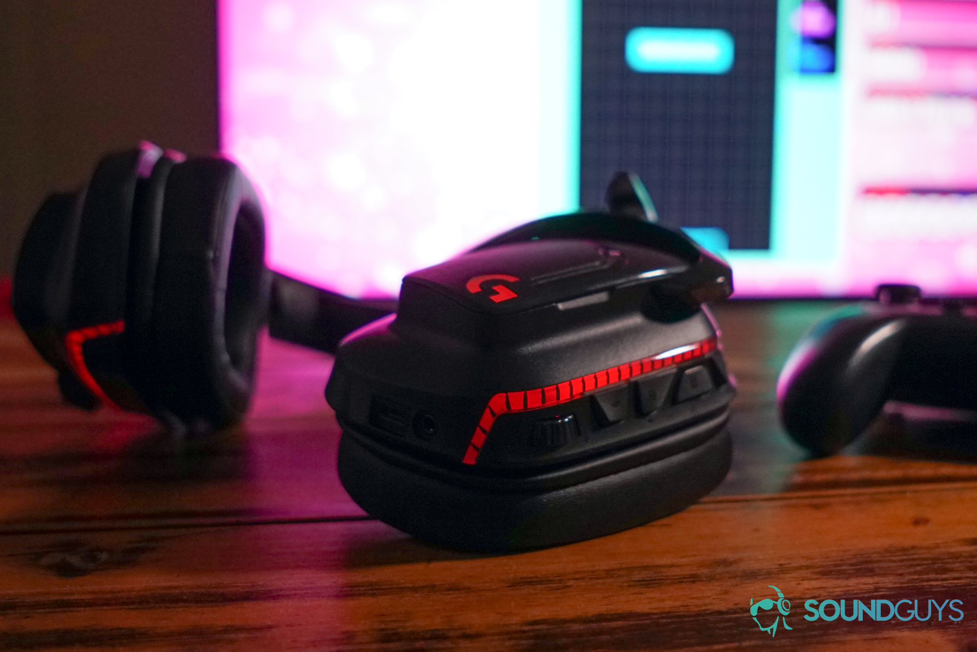 The Logitech G935 sits on a wooden table in front of a TV with a Nintendo Switch running Tetris 99, next to a Nintendo Switch Pro Controller