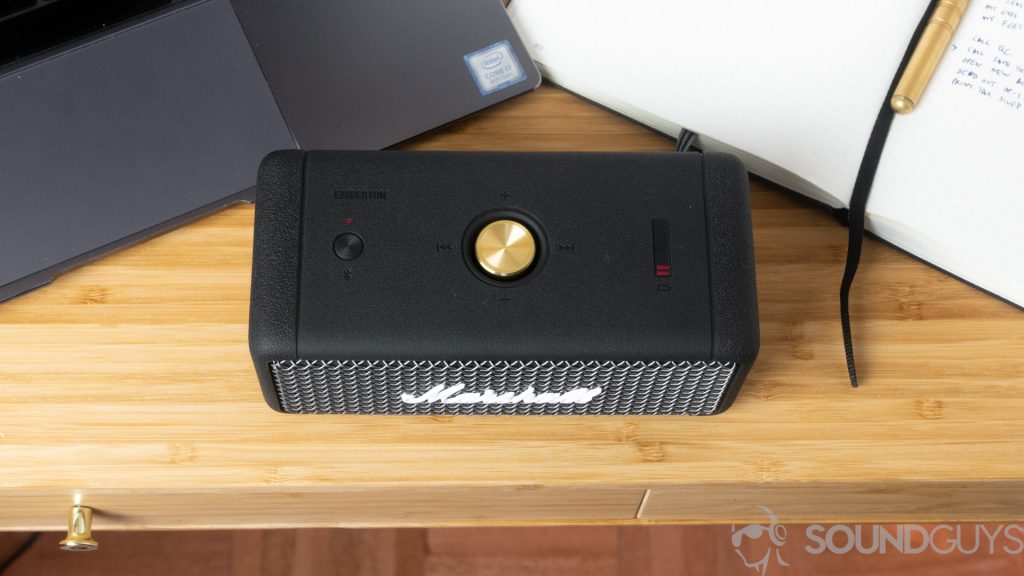 Shot of the top of the Marshall Emberton Bluetooth speaker next to laptop and a notebook