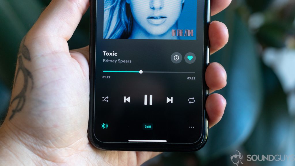 Man holding iPhone 11 Pro with Tidal playing a song optimized for 360 Reality Audio by Sony to help depict how to transfer Tidal playlists to another service.