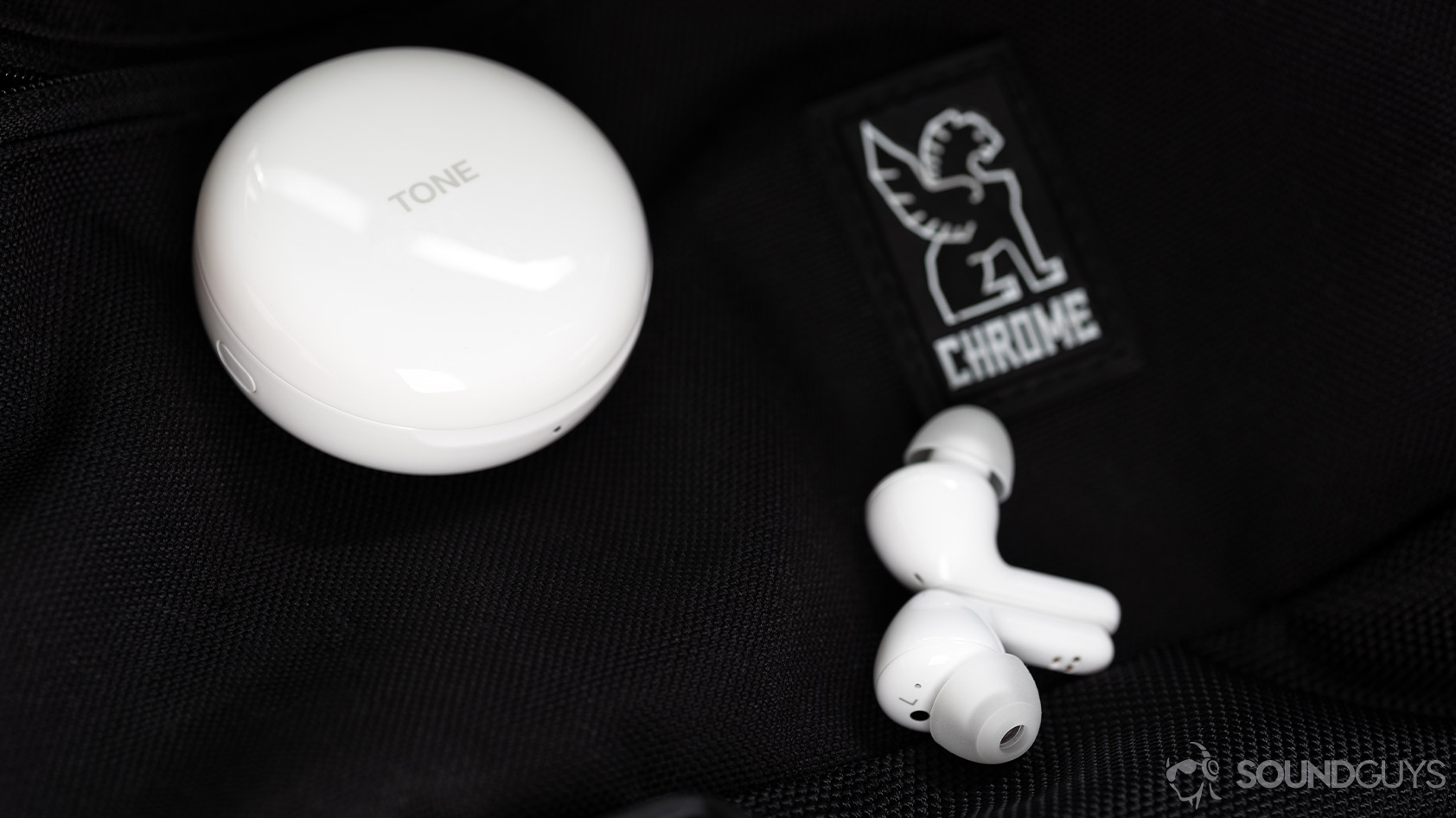 LG TONE Free HBS-FN6-true wireless earbuds stem AirPods alternative black background A photo of the LG TONE Free HBS-FN6-6 true wireless earbuds outside of the charging case showing the dedicated soft ear tips with the circular case in the background.