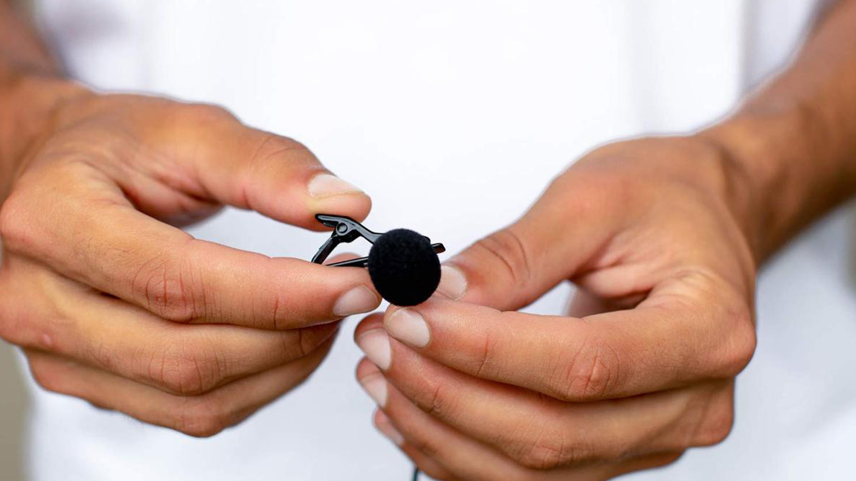 An image of the Movo PM10 Deluxe Lavalier in a man's hand.