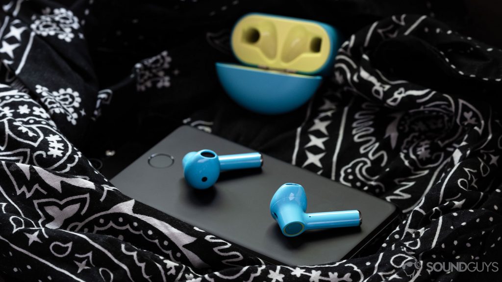 The OnePlus Buds true wireless earbuds (Nord Blue color) on a Google Pixel 3 smartphone with the earbuds charging case open in the background.