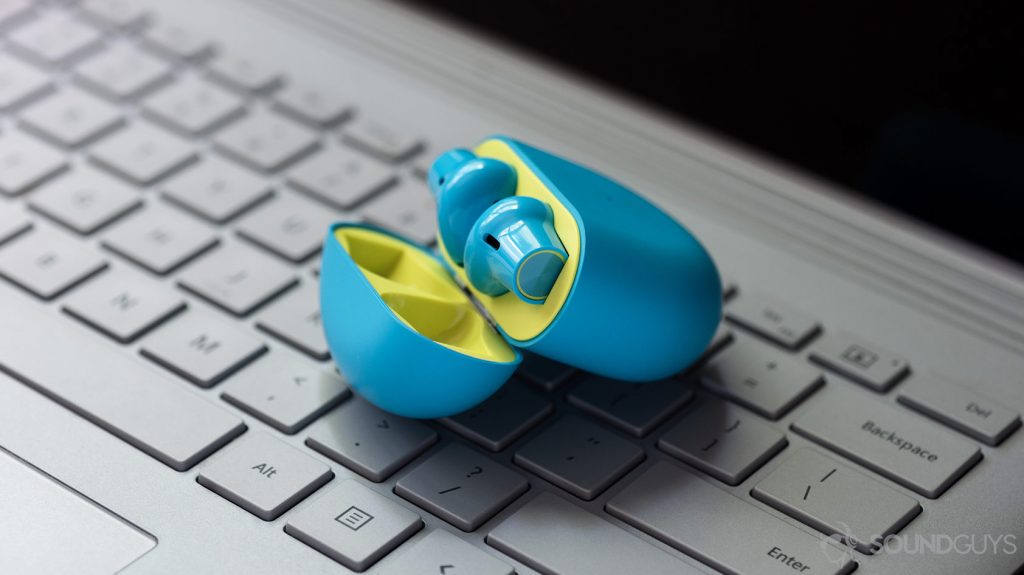 A picture of the OnePlus Buds true wireless earbuds in the open charging case atop a Microsoft Surface Book laptop.