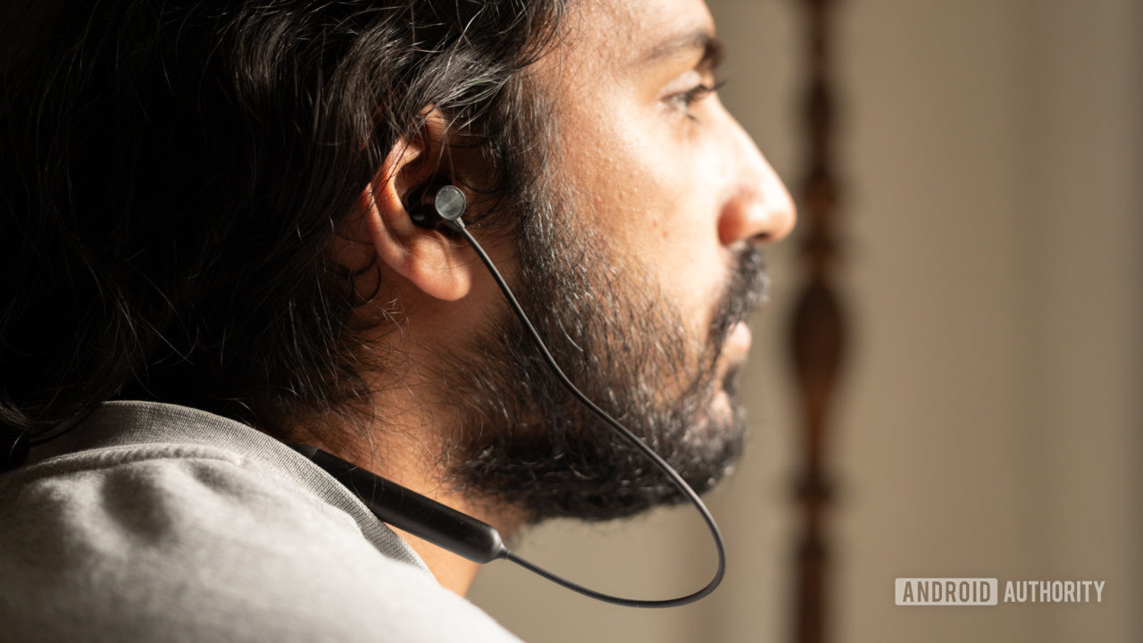 A picture of a man in profile wearing the OnePlus Bullets Wireless Z neckband earbuds.