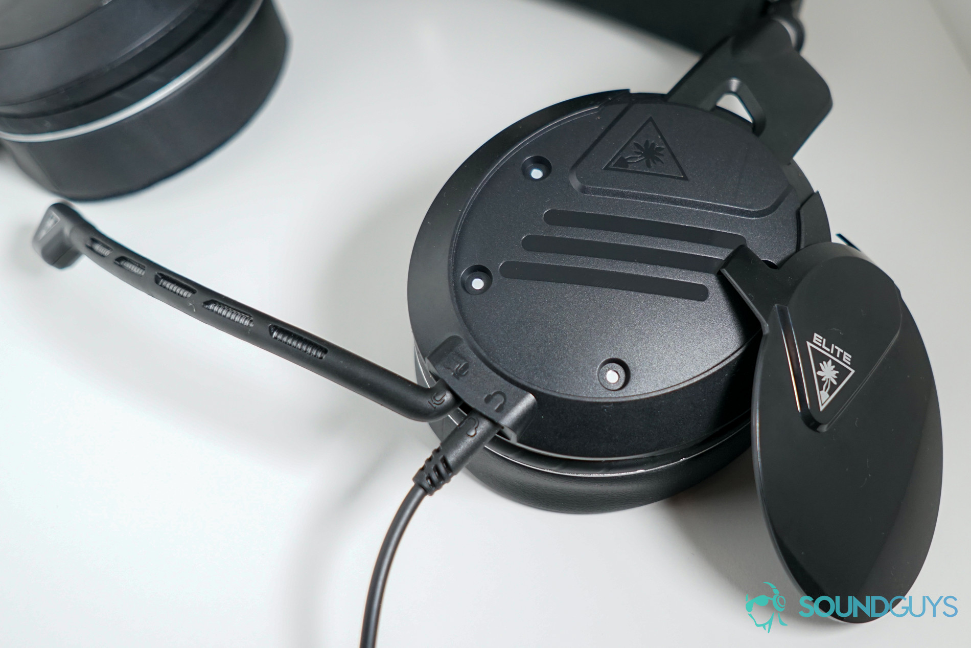 Turtle Beach Elite Pro 2 headphone plat and input shot The Turtle Beach Elite Pro 2 gaming headset lays on a white surface with its face plate off.