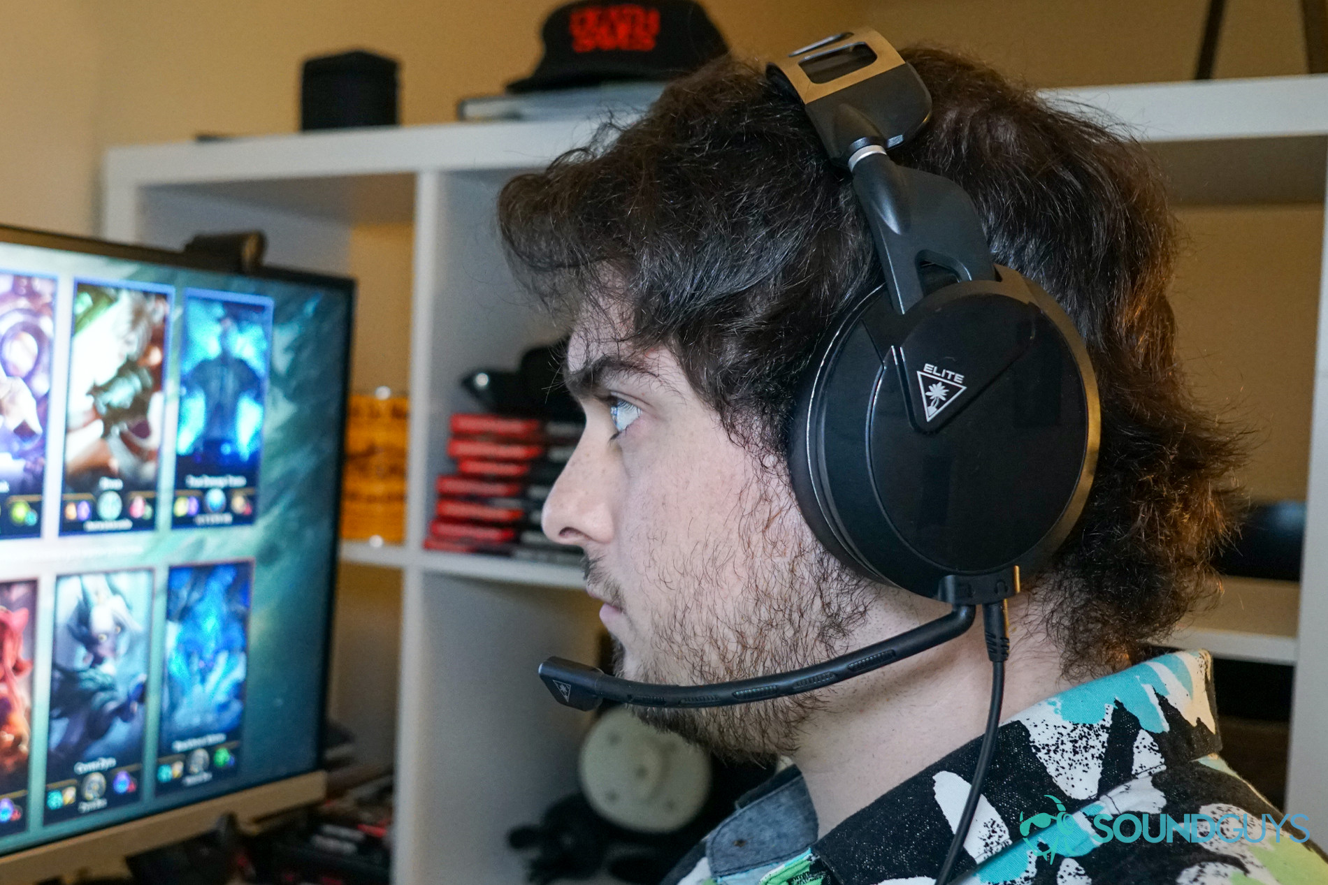 A man wears the Turtle Beach Elite Pro 2 sitting at a PC running League of Legends.
