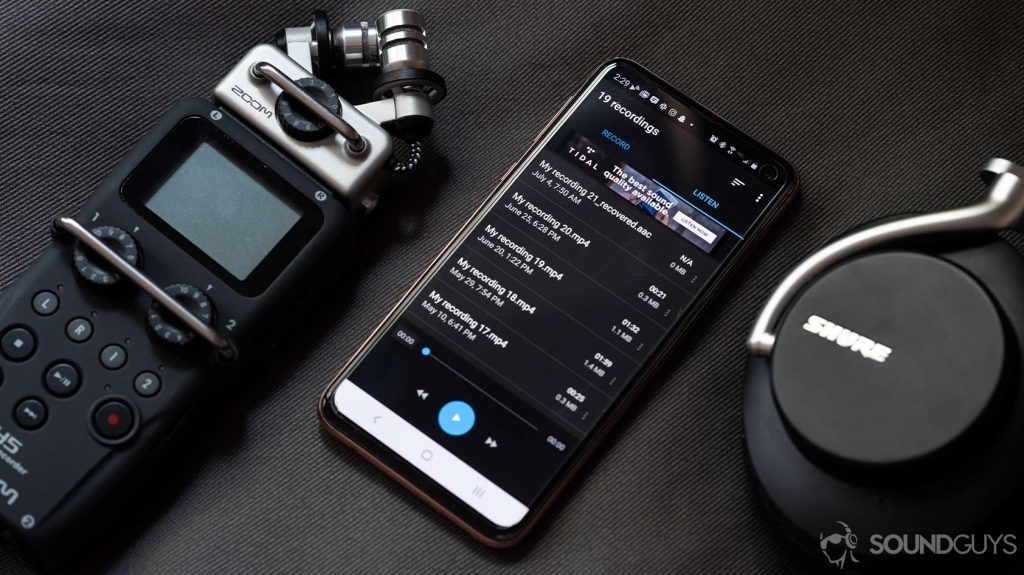 A picture of the Easy Voice Recorder app on a Samsung Galaxy S10e smartphone, flanked by a Zoom recorder and Shure noise cancelling headphones.