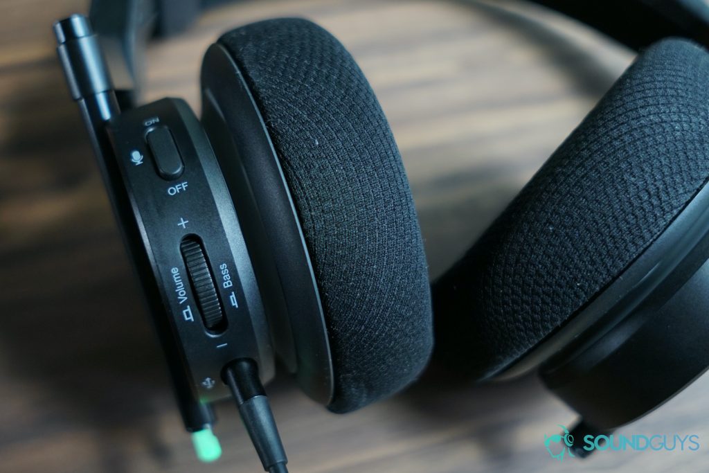 the 1more spearhead gaming headset sits on a wooden table with its on-ear controls facing up.