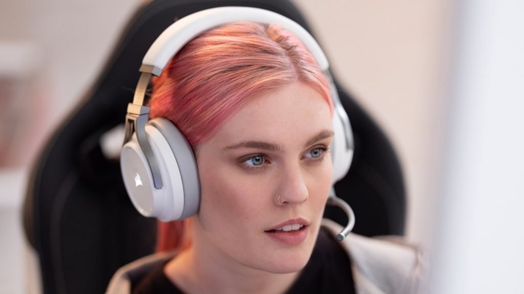 This is a picture of a woman looking off-screen wearing the Corsair Virtuoso Wireless RGB headset.