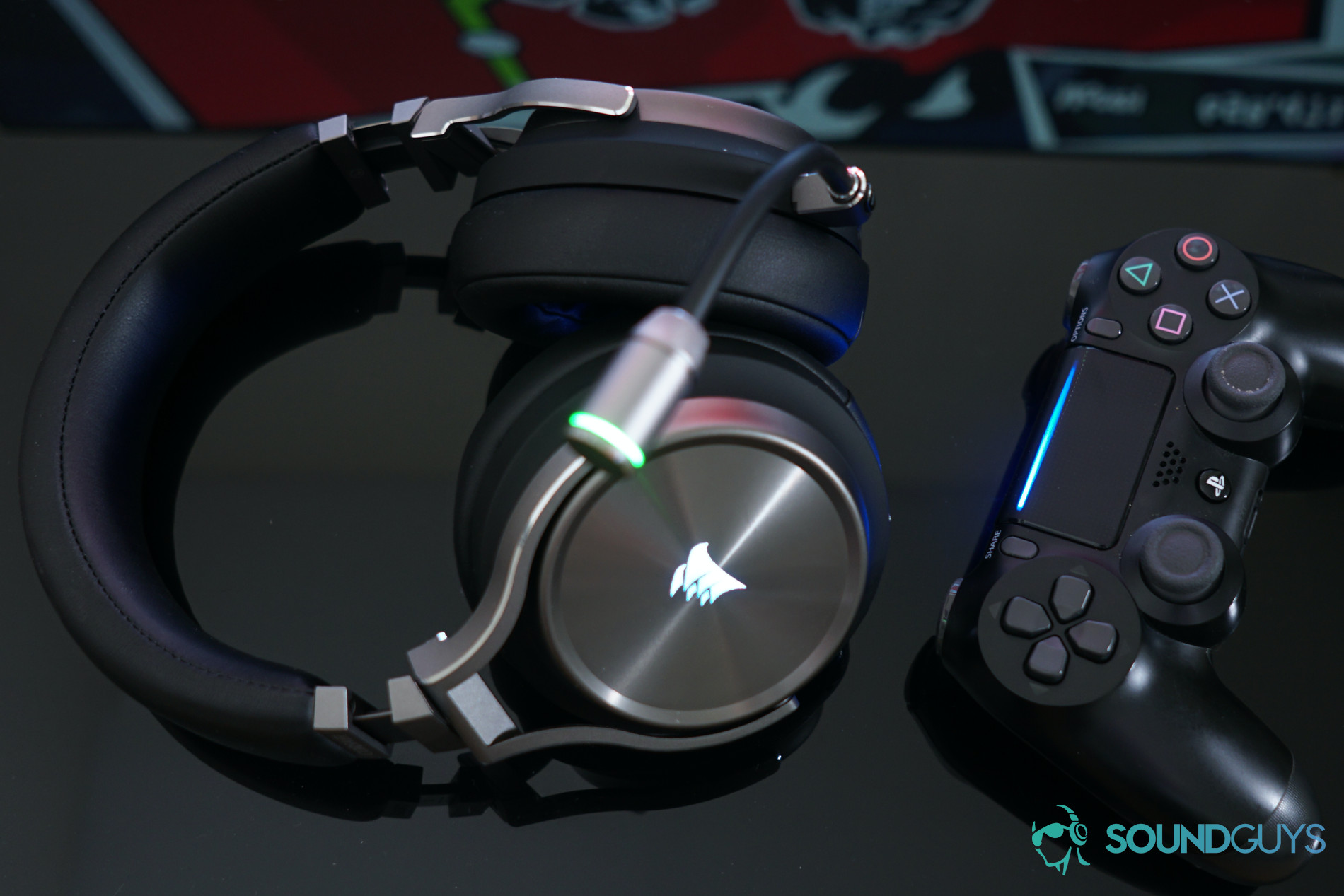 Il Corsair Virtuoso Wireless SE Over-Ear Gaming Aurione accanto a un controller PlayStation 4 su uno sfondo nero