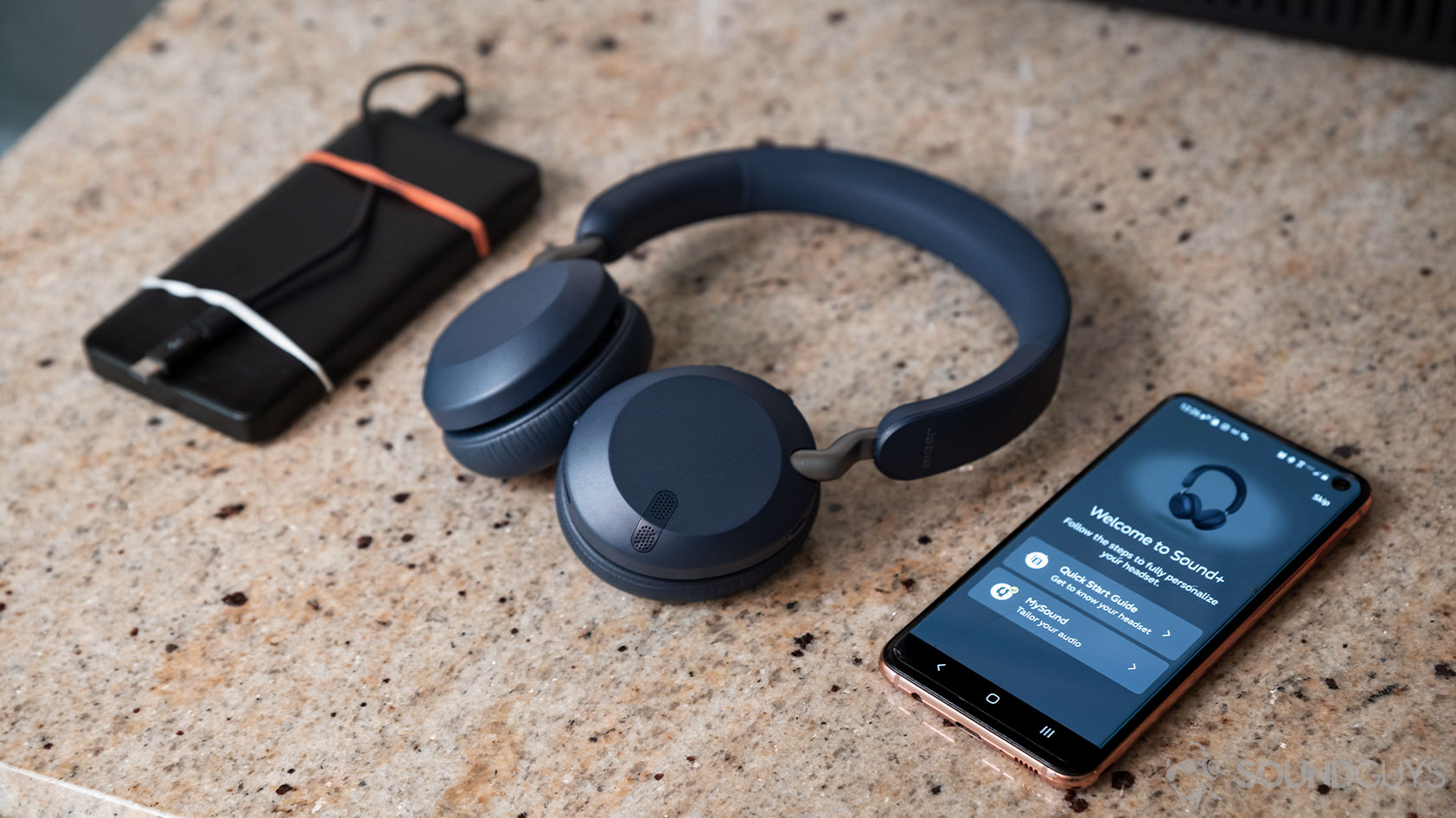 The Jabra Elite 45h on-ear Bluetooth headphones next to a Samsung Galaxy S10e smartphone with the Jabra MySound+ application open.