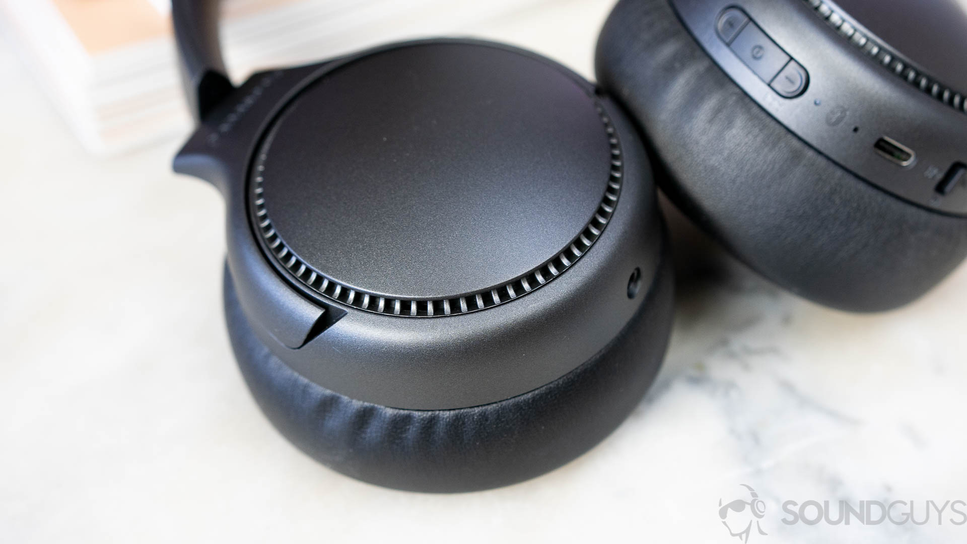 Close-up shot of the earcups of the Panasonic RB-M700B headphones on top of marble table.