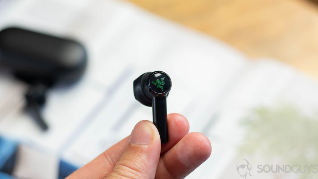 Man holding a single Razer Hammerhead earbud