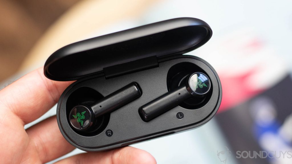 Man holding the Razer Hammerhead true wireless earbuds in the charging case