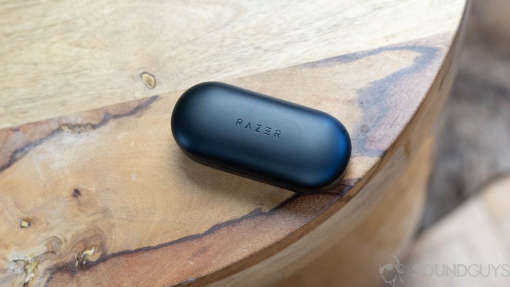 The Razer Hammerhead true wireless earbuds charging case pictured on a wooden stool