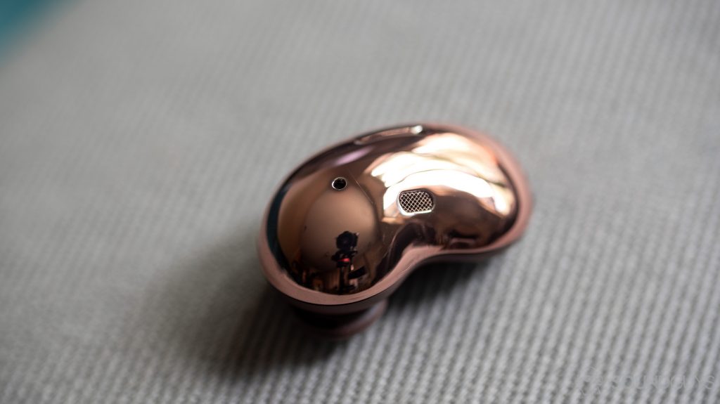 A picture of the Samsung Galaxy Buds Live noise cancelling true wireless earbuds bean shaped, reflective exterior; the earbud is at angle.