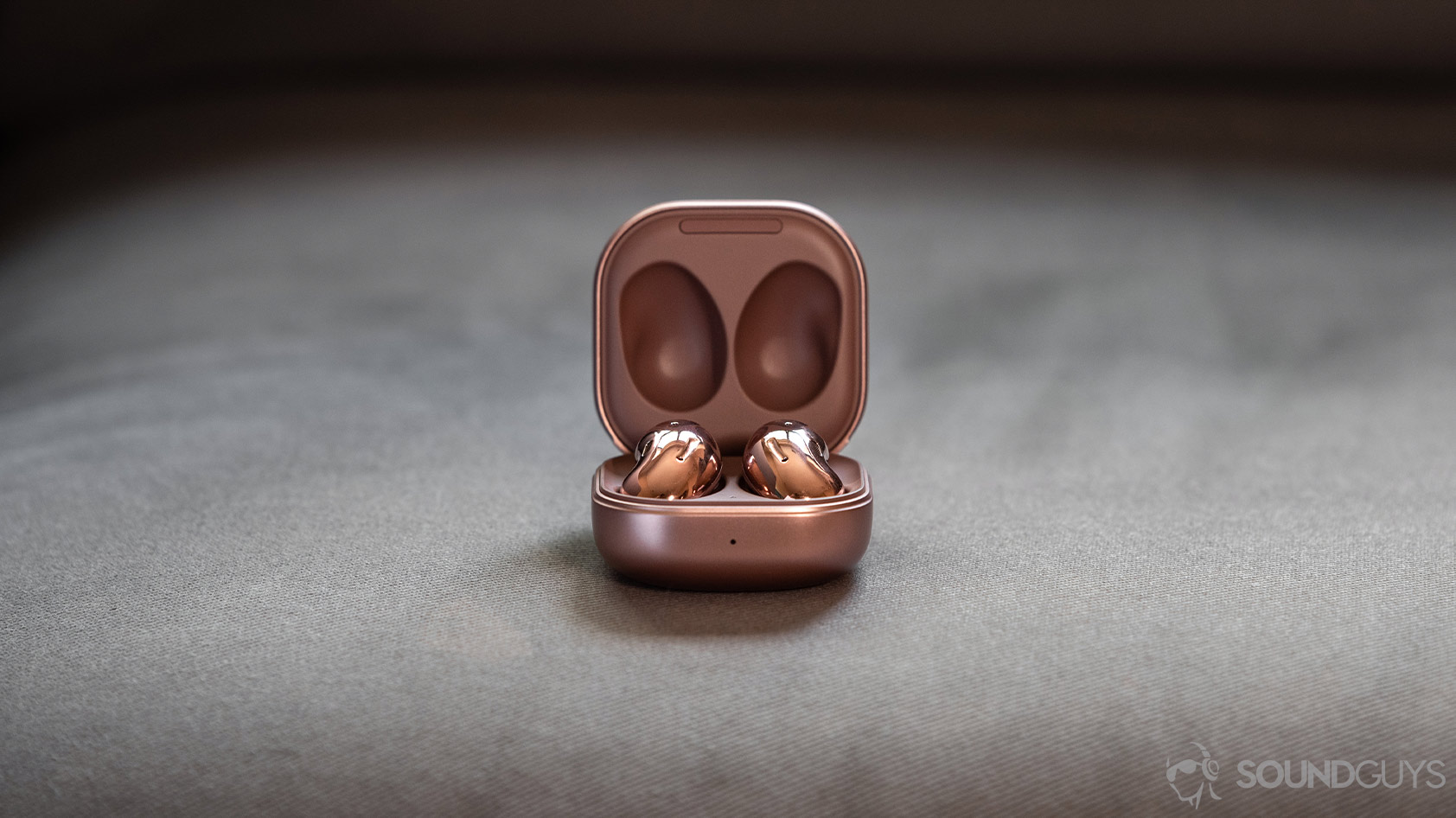 A picture of the Samsung Galaxy Buds Live noise canceling true wireless earbuds in the case against a gray background for a comparison in the Apple AirPods vs Samsung Galaxy Buds Live breakdown.