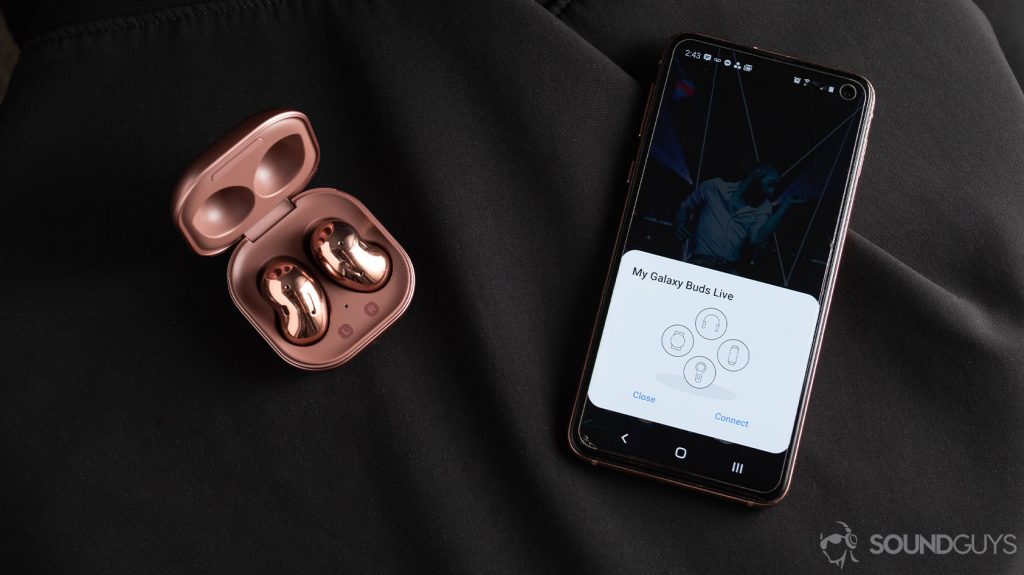 A picture of the Samsung Galaxy Buds Live noise canceling true wireless earbuds in the open case next to a Samsung Galaxy S10e smartphone with quick pairing.