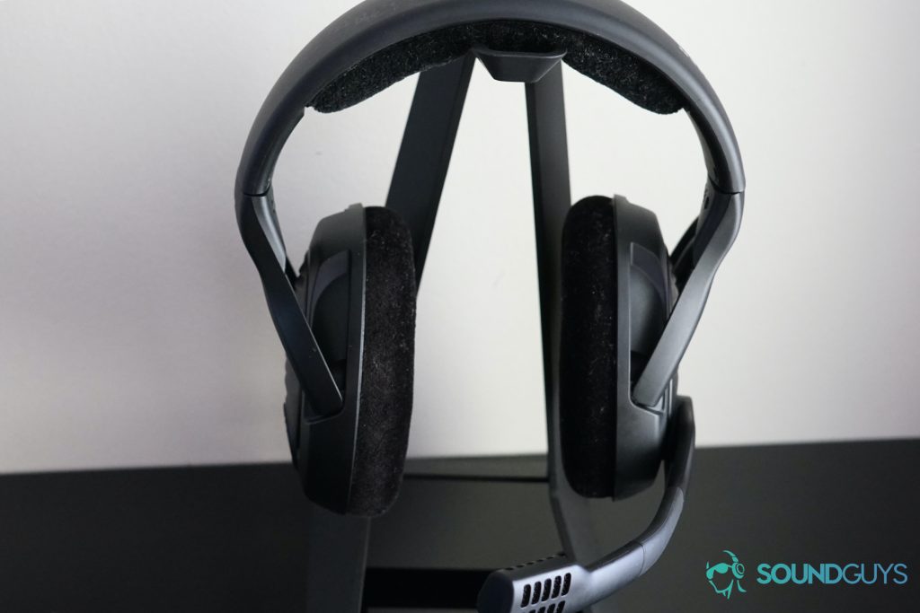 The Sennheiser PC37X sits on a headphone stand against a white wall.
