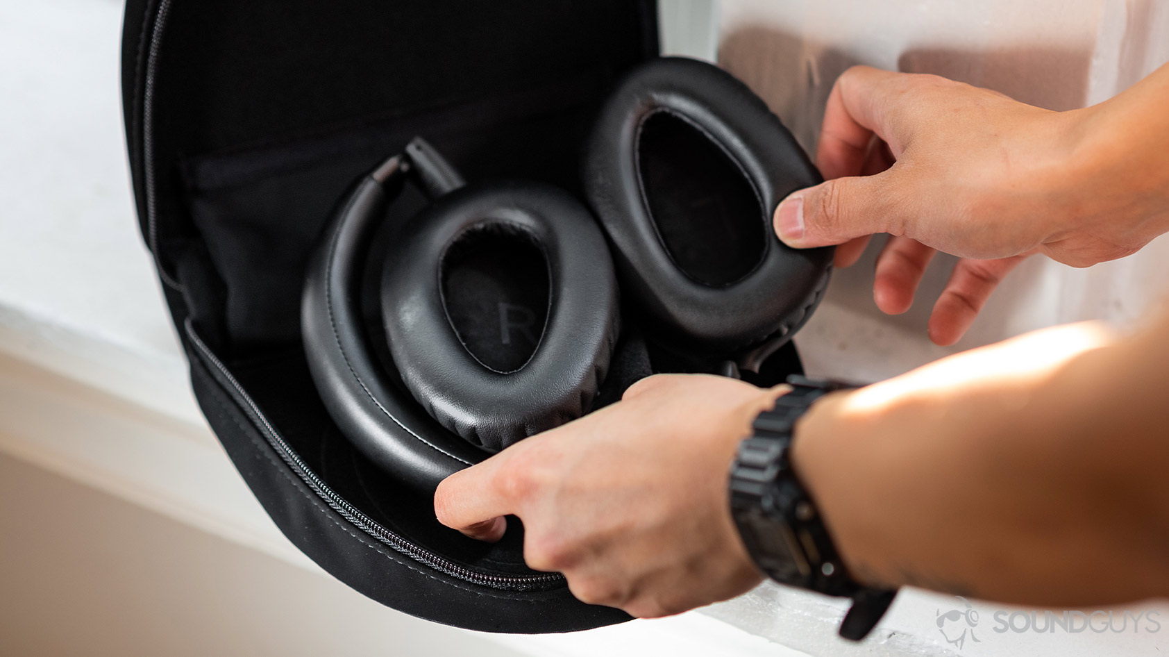A picture of the Sennheiser PXC 550-II noise canceling headphones being placed into the travel case.