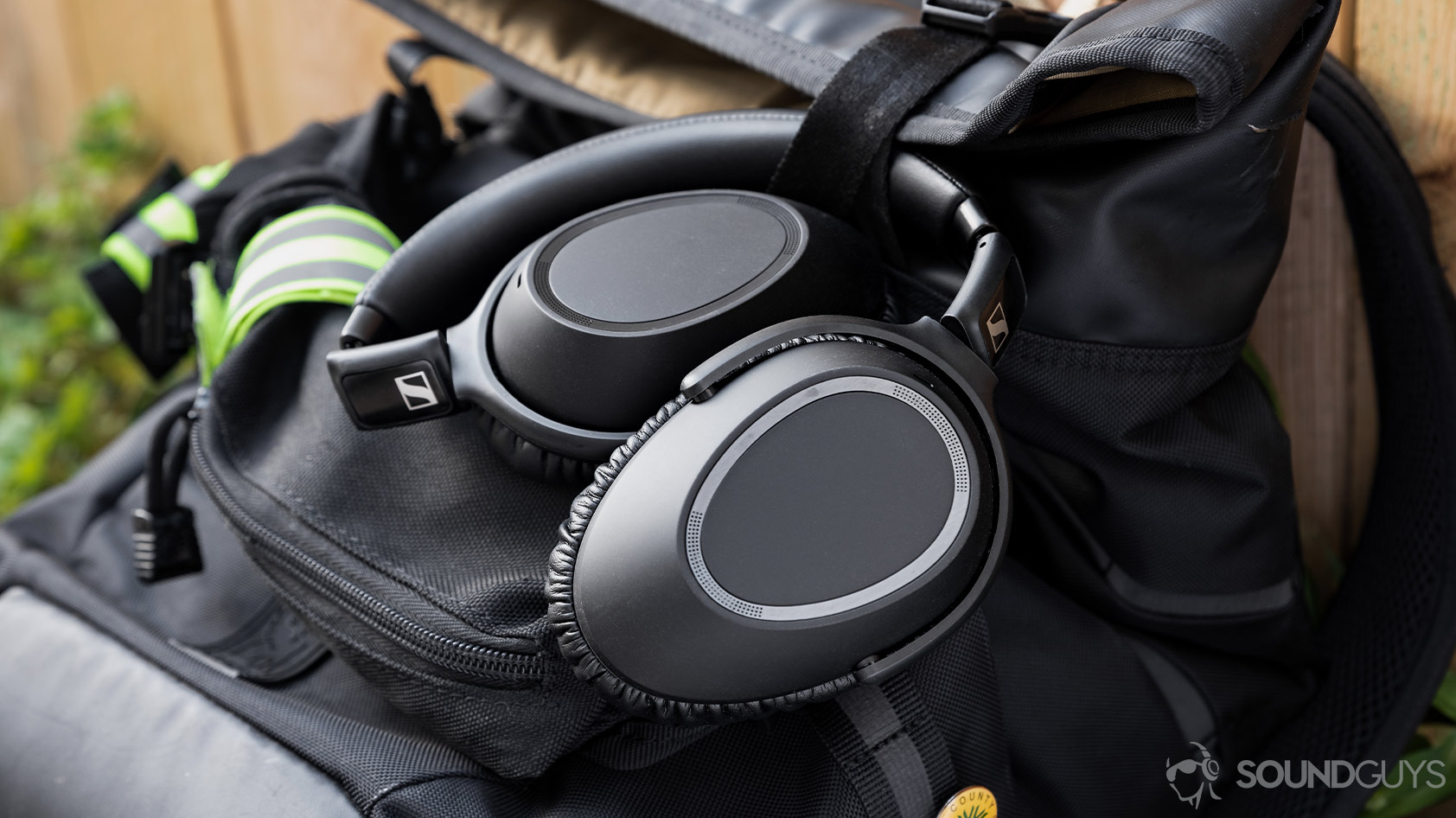 The Sennheiser PXC 550-II noise canceling headphones folded on the outside of a backpack.