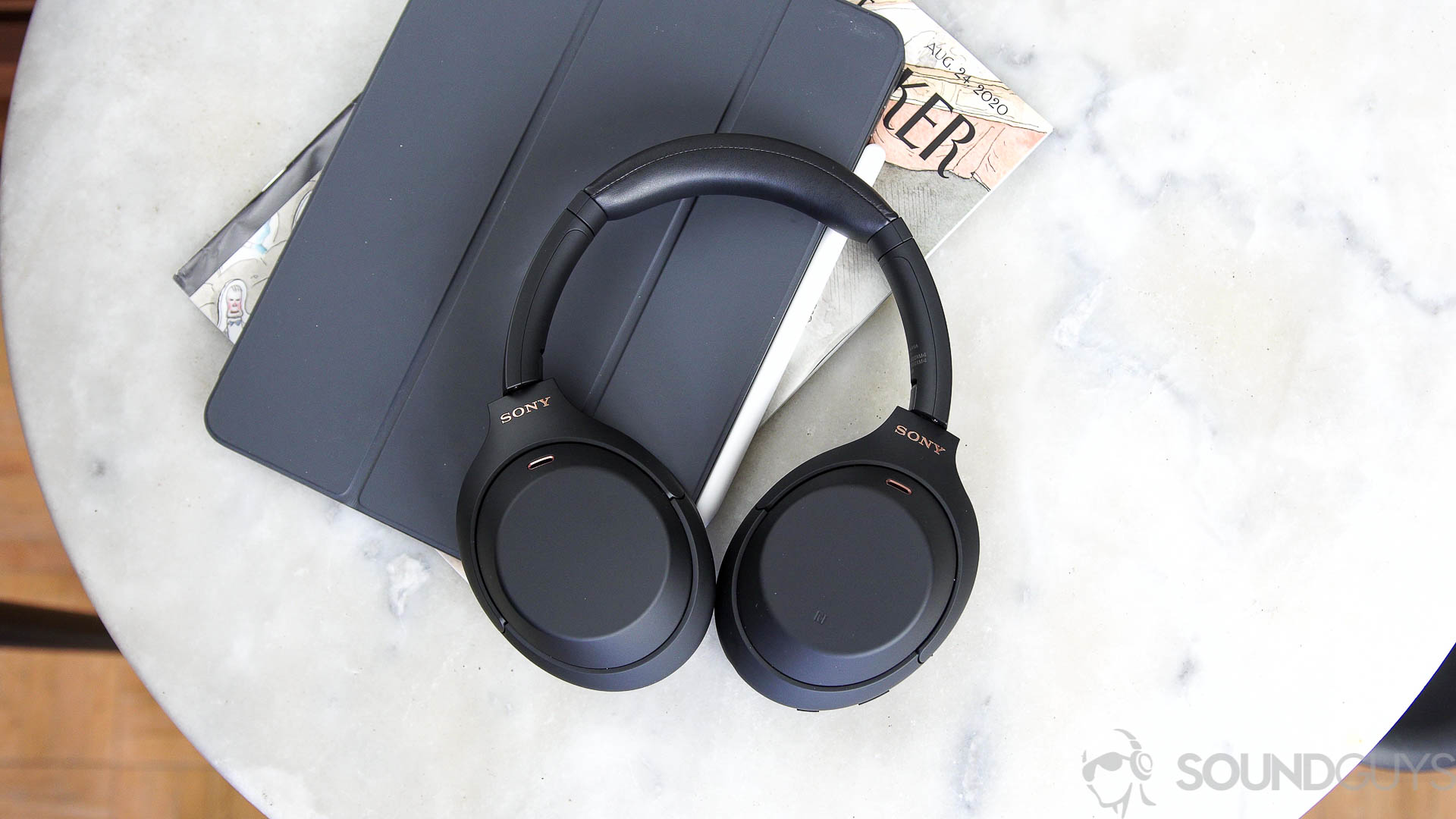 Sony WH-1000XM4 headphones next to iPad Pro on a marble surface