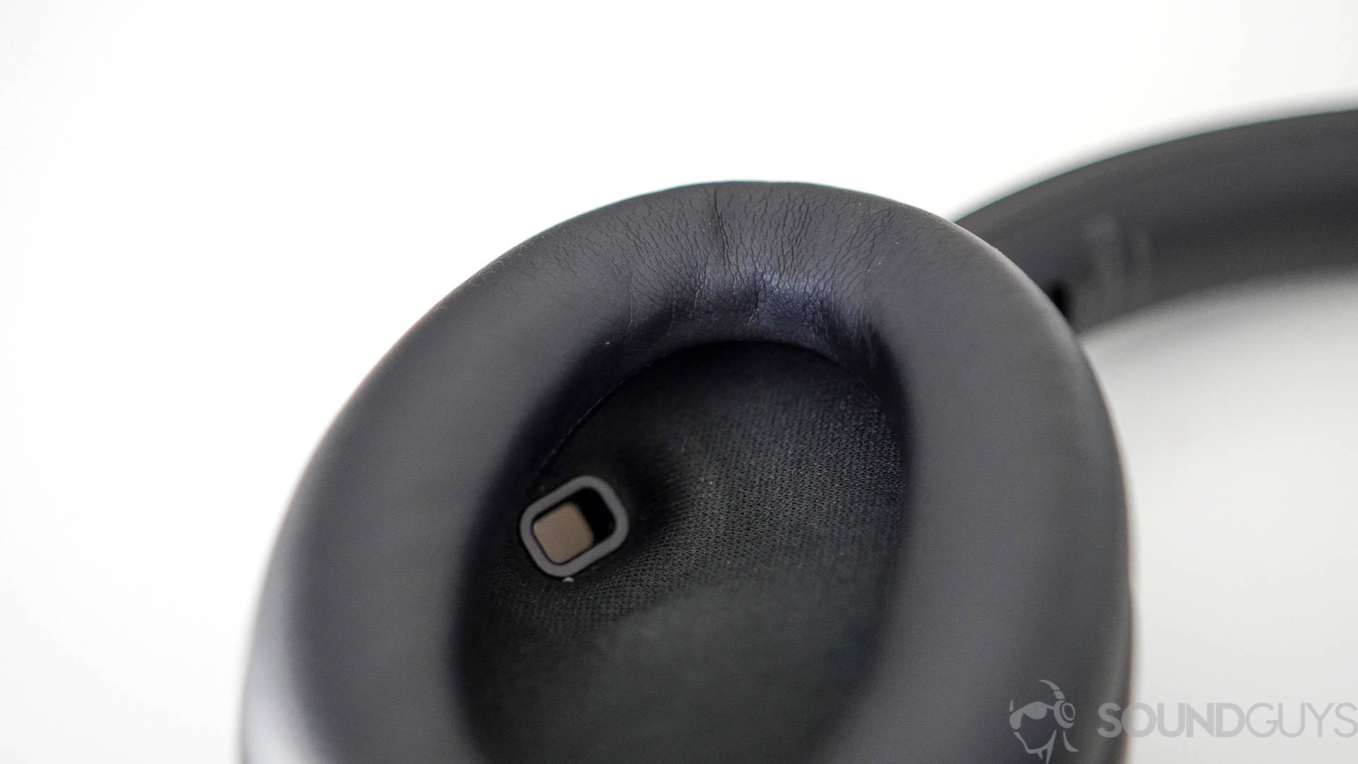 Close-up of the proximity sensor on the inside of the left earcup of the Sony WH-1000XM4 headphones.