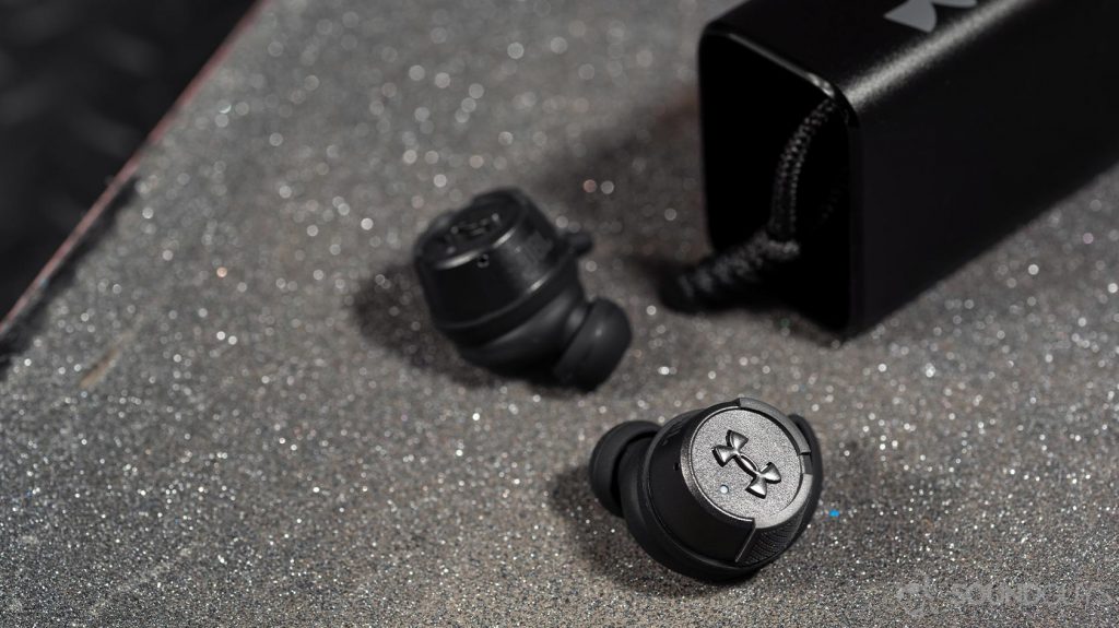 A photo of the UA True Wireless FLASH X by JBL earbuds with Under Armour logo facing the camera.