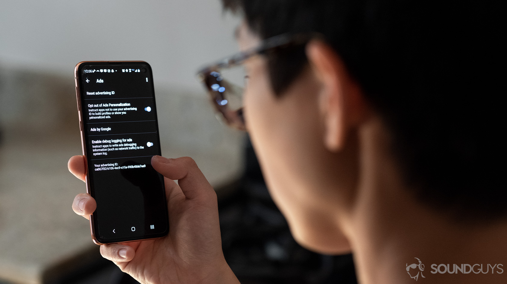 headphone data collection-google ad id A woman disabling Google Ad ID functionality on a smartphone.